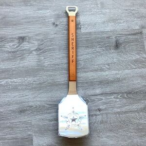 The Sportula sheriff department spatula with bottle opener end